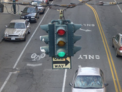 Our editors provide offer some helpful essay writing tips. A photograph of a traffic light suspended above a busy intersection. This image is meant to parallel traffic signals and essay writing.