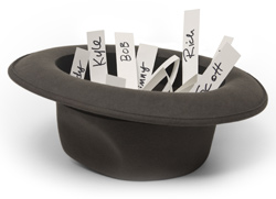 A top hat is lying upside down on a white background. Inside the hat are slips of papers with names written on them.