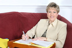 Our editors discuss five habits to avoid in academic writing. A female professor is sitting on a red couch reviewing her student's academic writing.