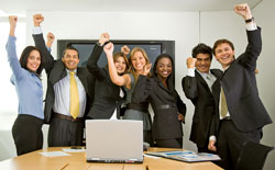 Our editors explain what a business pitch is and how to write one. A group of young businesspeople have their hands up in the air in excitement because they made a successful business pitch.