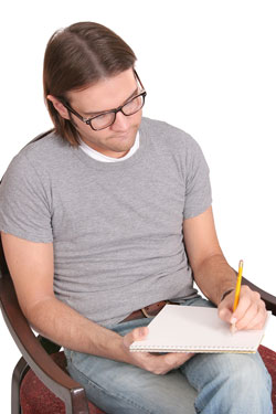 Our editors provide tips on how to write a character sketch. A man with long hair and glasses writing a character sketch.