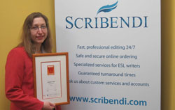 Scribendi.com President, Chandra Clarke, holds the PROFIT Magazine W100 plaque in front of a Scribendi.com sign.