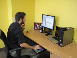 One of our in-house editors hard at work. Scribendi.com's in-house editor is sitting at his desk editing a document on his computer.