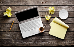 Scribendi.com suggests some starting points for writing screenplays. A computer, coffee, and crumbled papers sit next to a calendar.