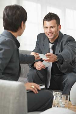Our editors provide an overview of the combination resume, targeted resume, and mini resume. Two business people sitting on a lounge exchanging mini resumes and discussing their combination and targeted resumes.