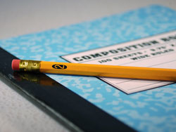 Our editors provide advice about how to write an essay introduction. A pencil lying on a blue notebook with the word "composition" across the front.