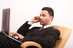 Our editors provide a query letter sample to help you along in the publishing process. A publishing agent is sitting on a chair with his cell phone to his ear. He is reading a query letter sample.
