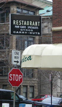 A restaurant sign that reads: "Pan-Cakes Specialists, Gyros, Carry-Outs." There is a misuse of hyphenation.