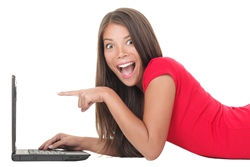 Subscribe for a chance to win free access to GrammarCamp.com. Smiling woman resting at her laptop.