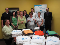 Scribendi.com staff collect 192 shirts for charity in shirt drive. Scribendi.com staff stand with the clothing they collected in their shirt drive.