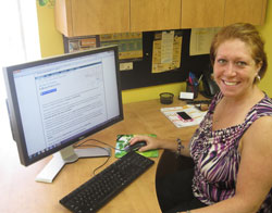 Scribendi.com's VP of Operations is sitting at a desk with the e-book publishing services open on her desktop.