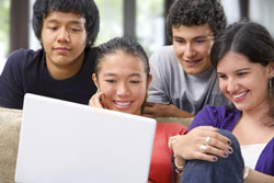 Our editors test your English skills with our homophone worksheet. Four culturally diverse students sitting around a computer smiling. They are working on a homophone worksheet.