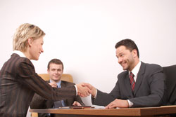 Two publishers are sitting a desk discussing what publishers services to offer a client.