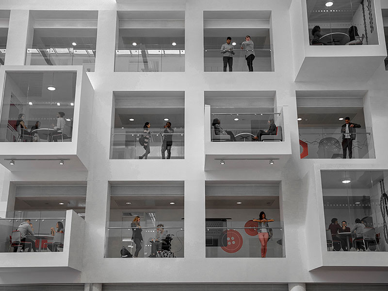 An office building with workers working in the windows.